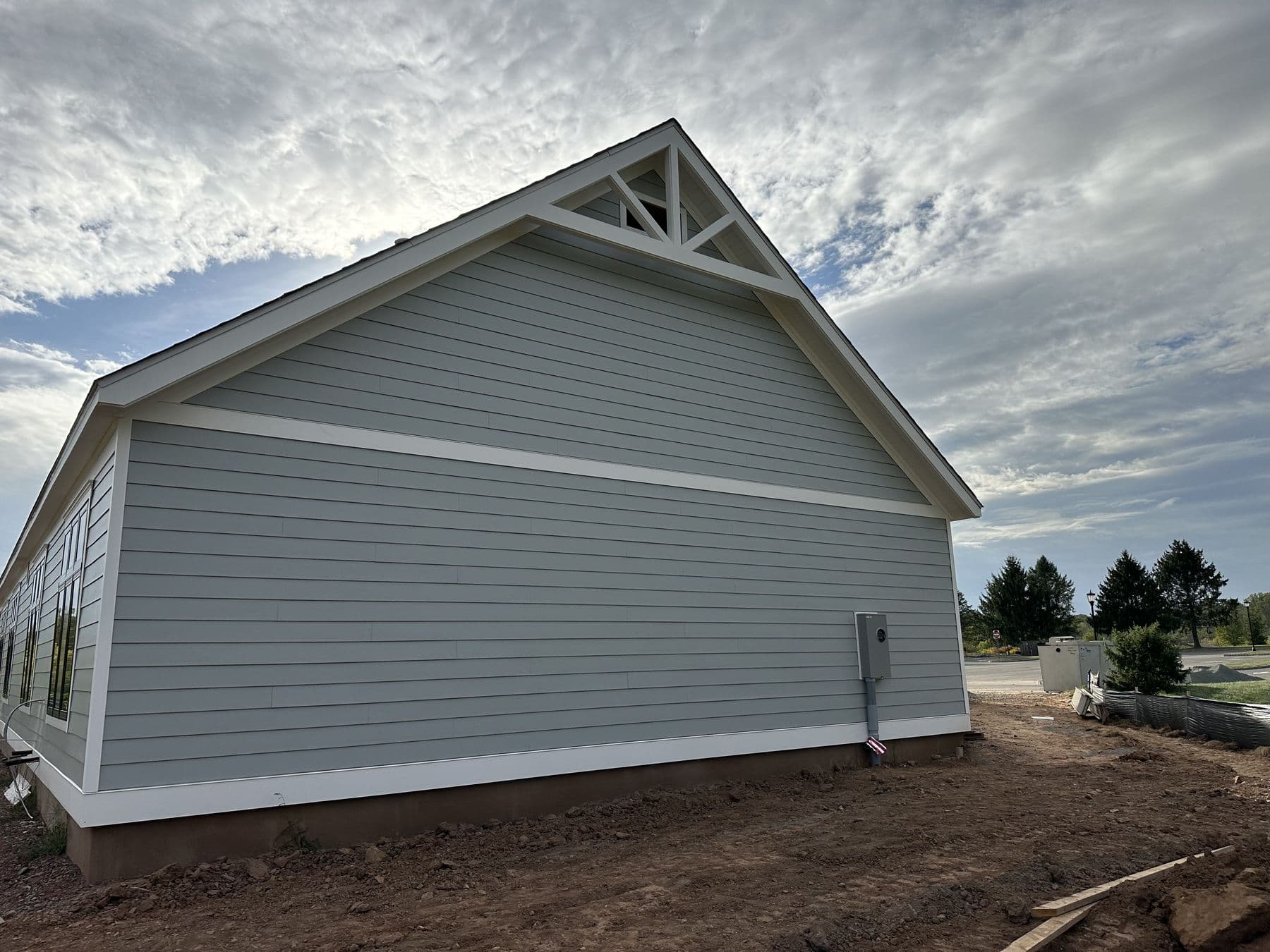 Gray siding on the gable end with white frieze and corner boards