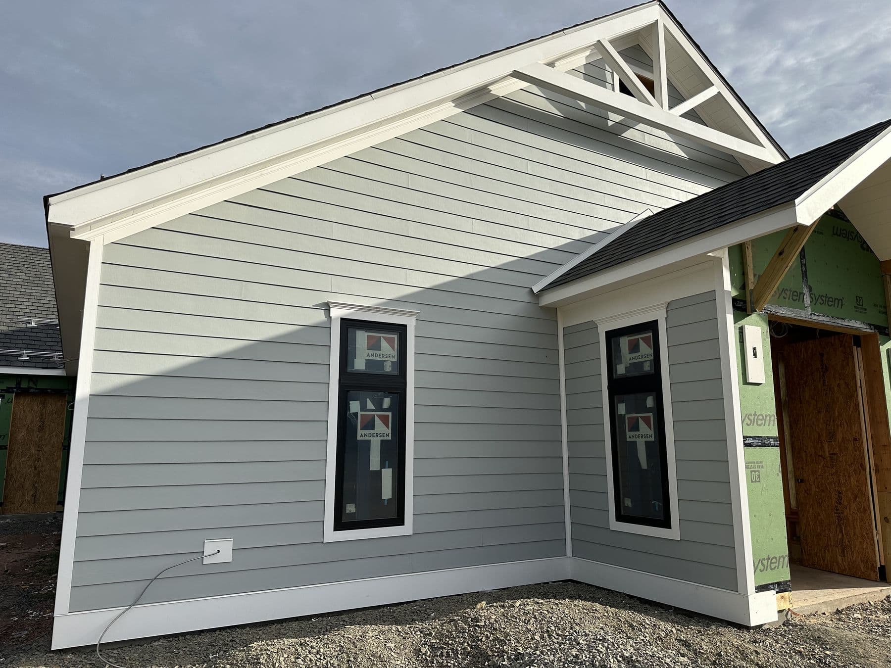 Front gable with a white timber truss, siding and black windows