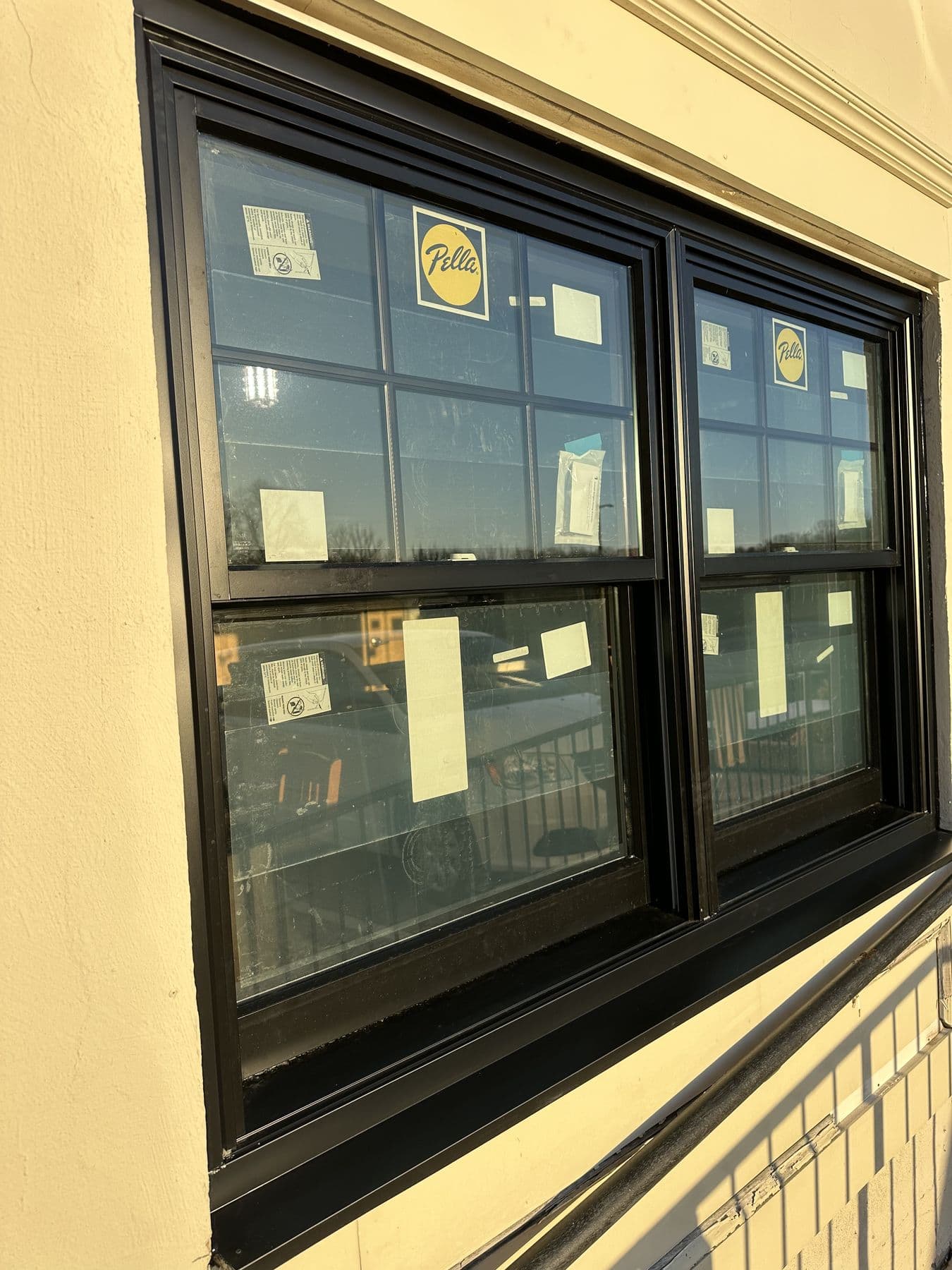 Close-up of a new black double window with labels on the glass