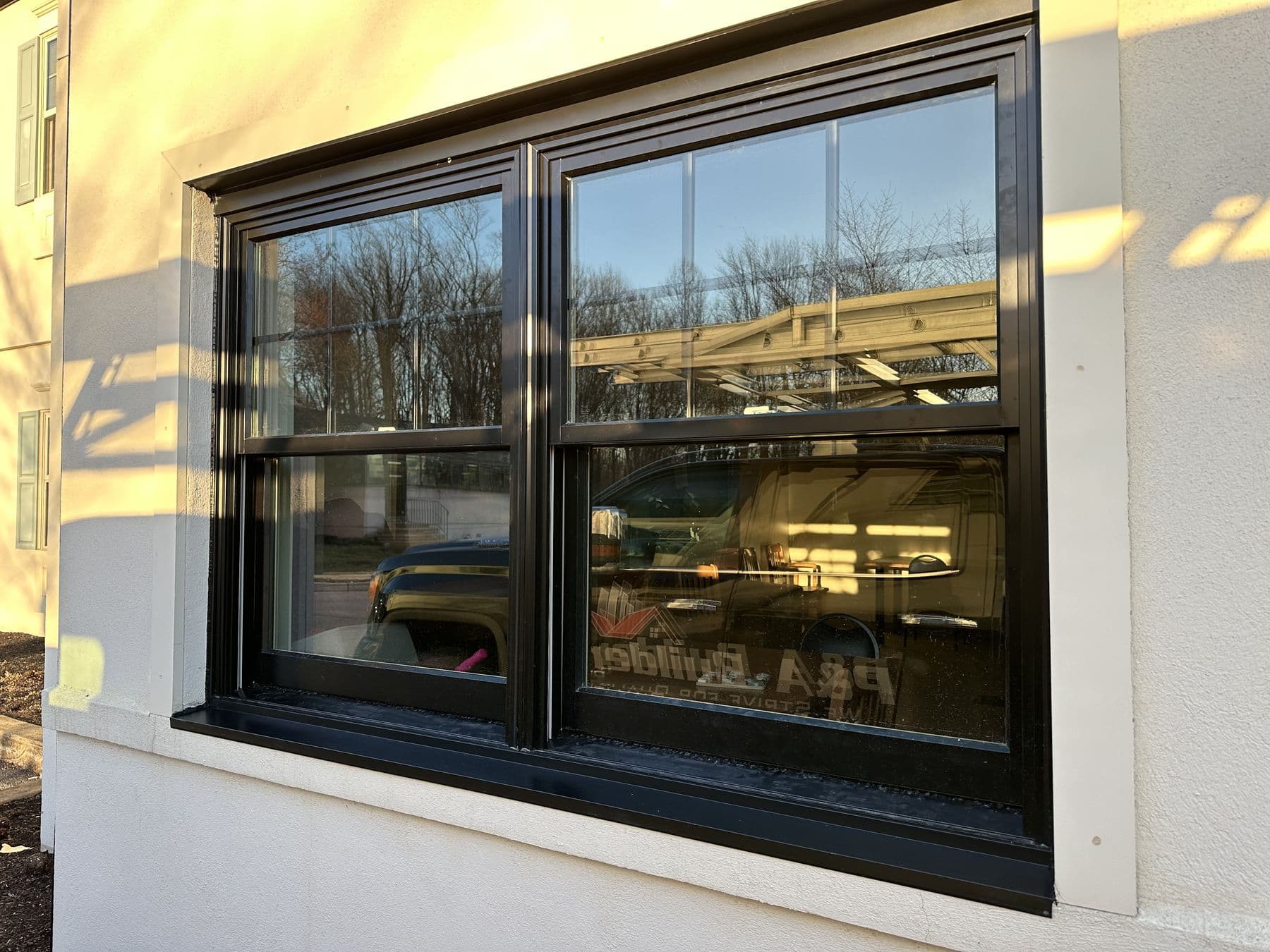 New black window in the white painted wall of the office building