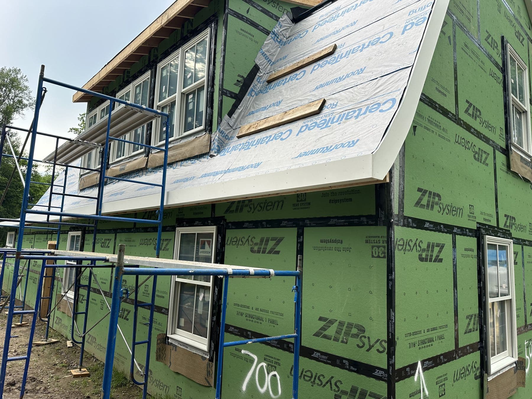 Scaffolding along the ZIP sheathed gambrel addition with new windows in the second floor