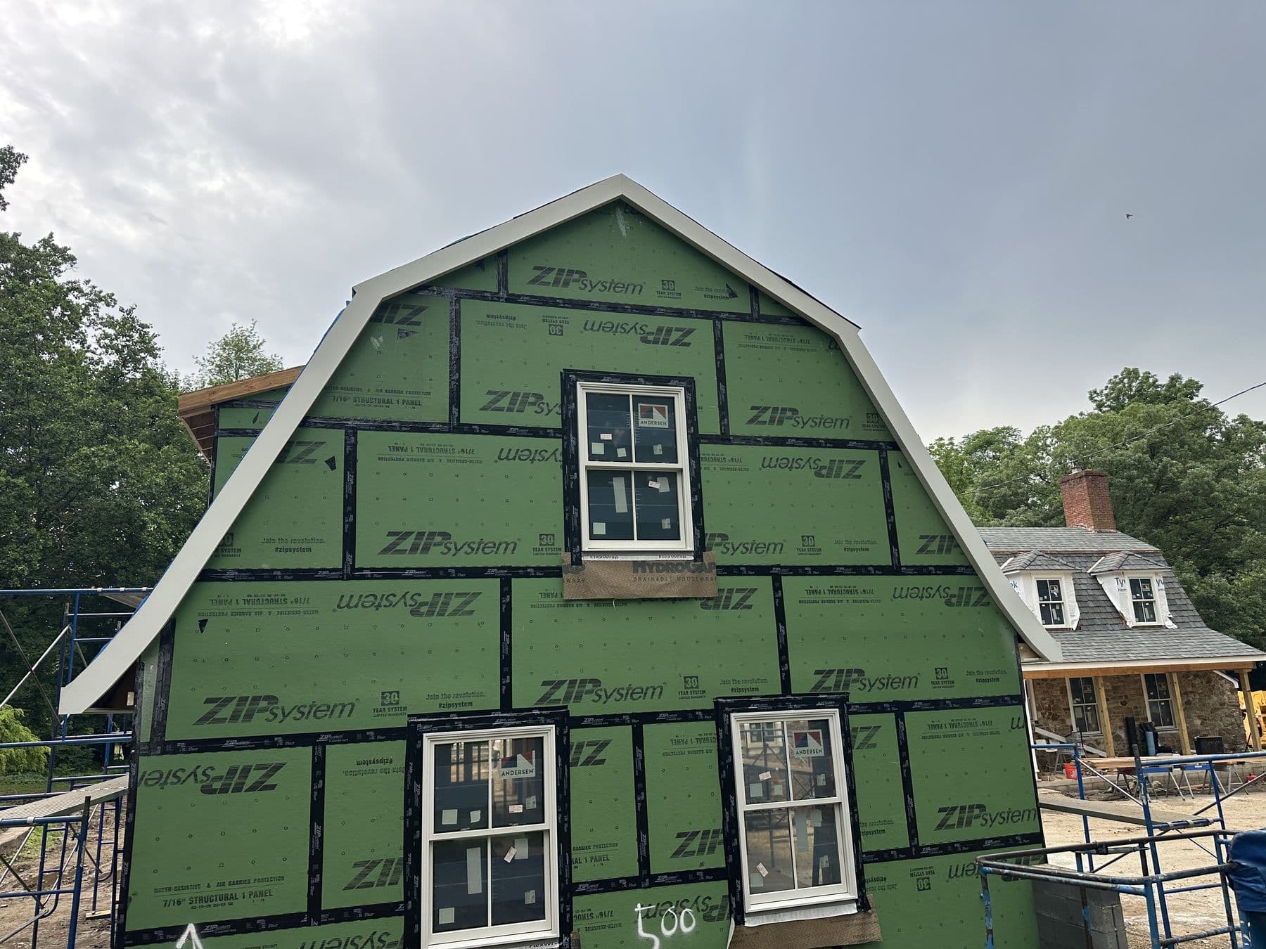 Gambrel addition gable in ZIP System sheathing with taped seams and two new windows