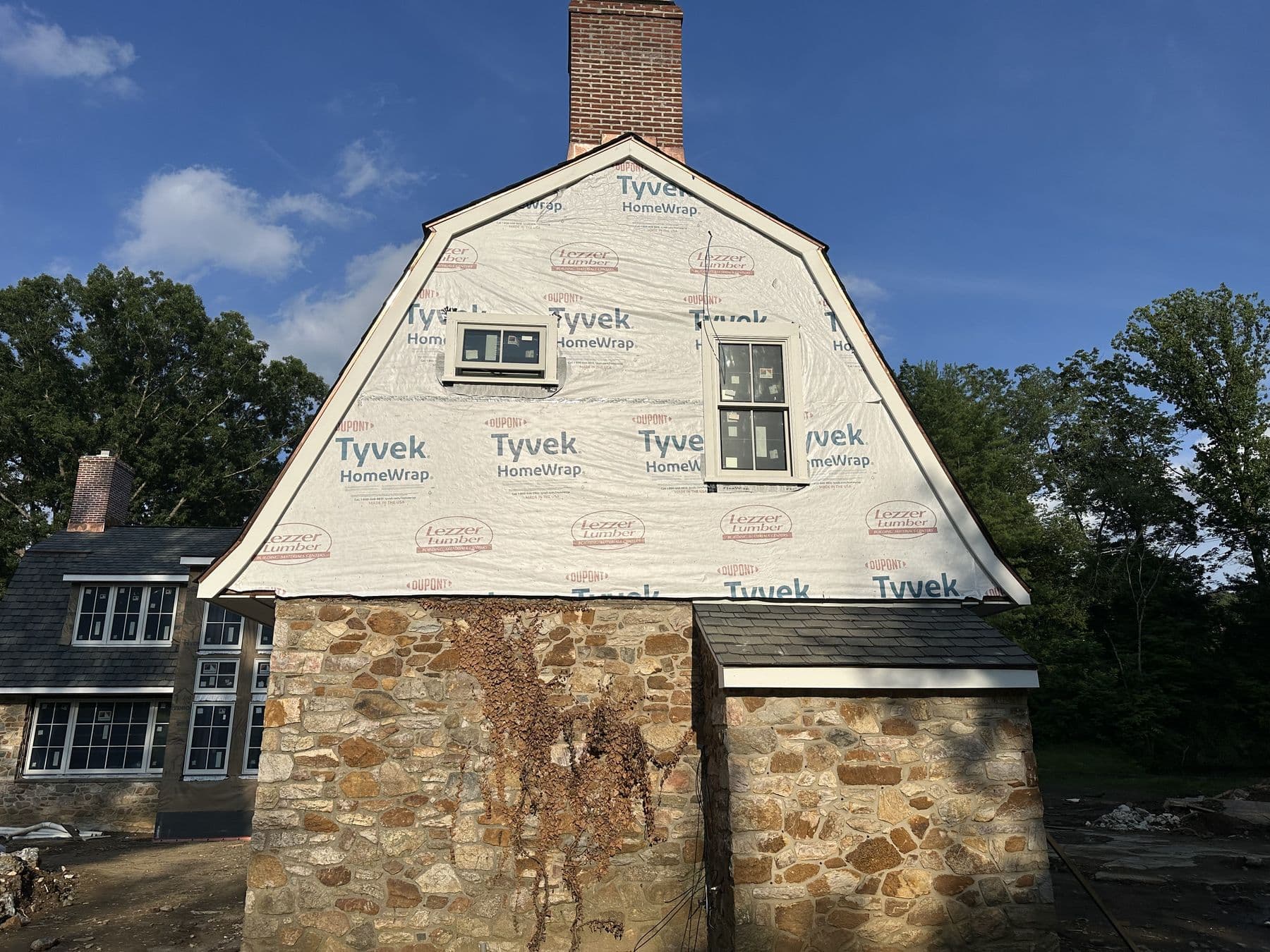 Gambrel gable over the stone garage, wrapped and ready for siding