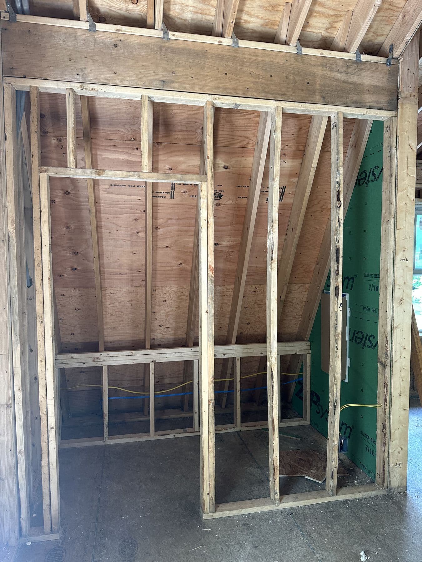 Framed interior wall with a new door opening inside the gambrel addition