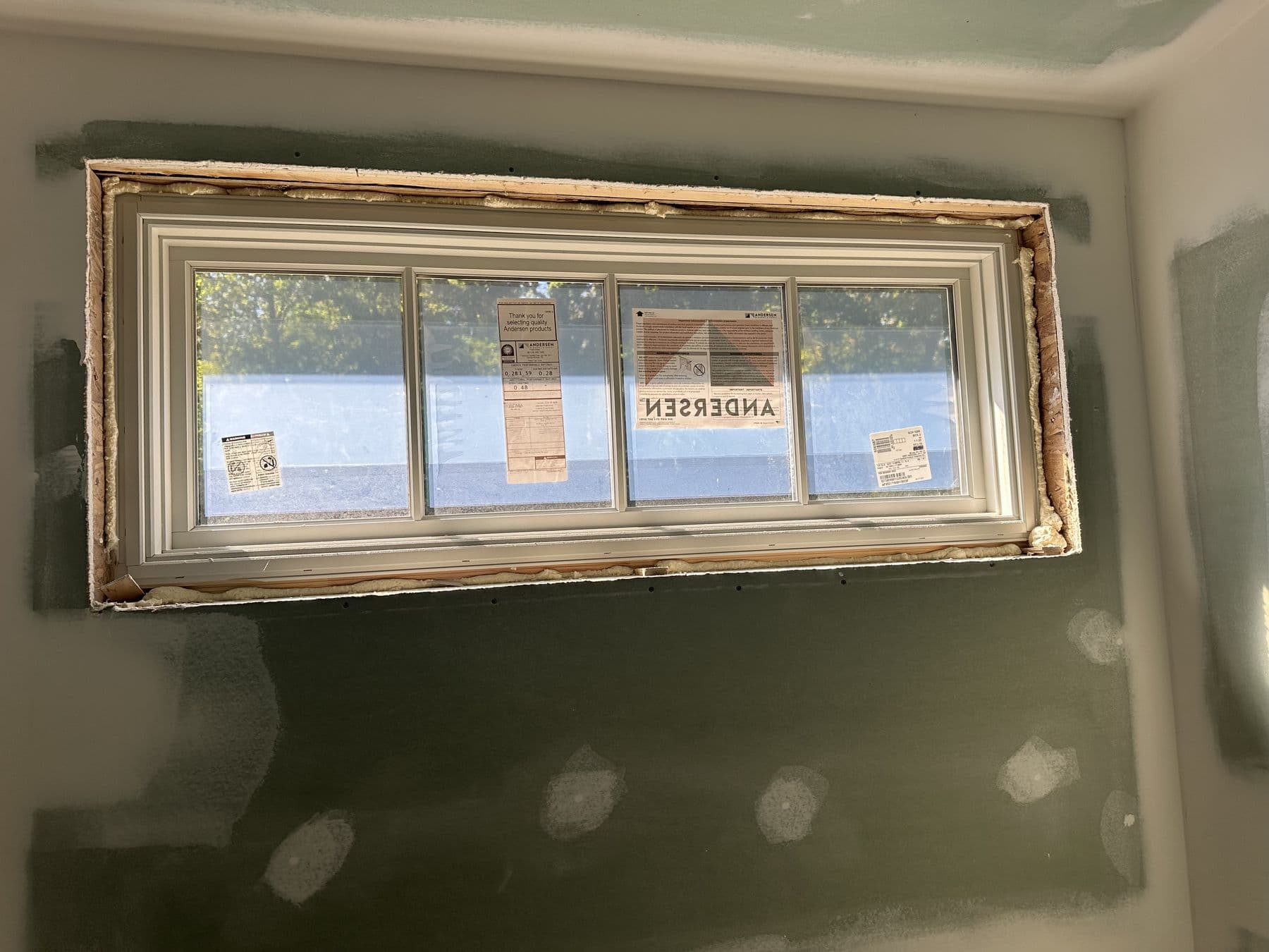 Andersen window set in a new opening before interior trim, labels still on