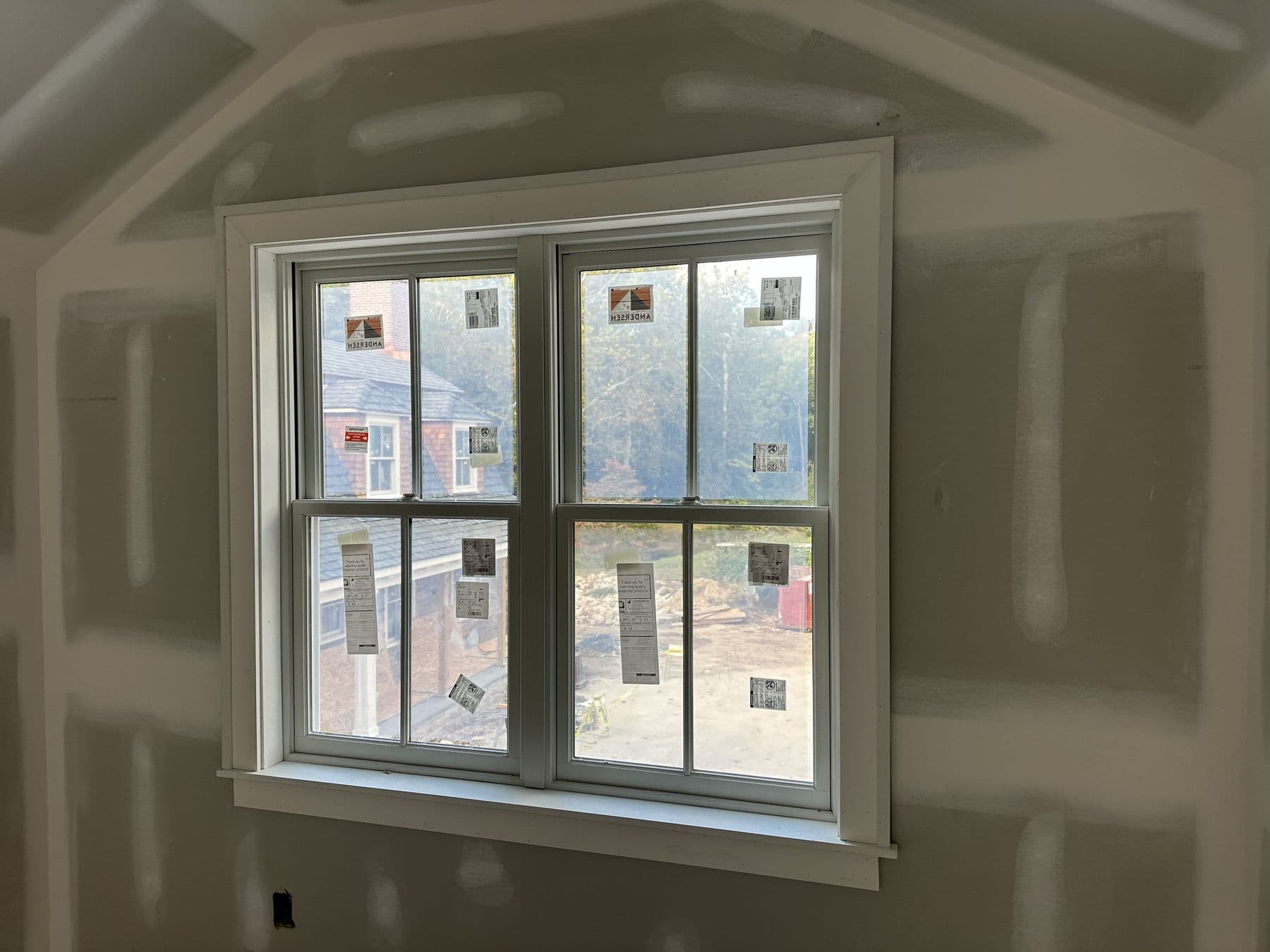 Single double-hung window with new white casing in a finished drywall room