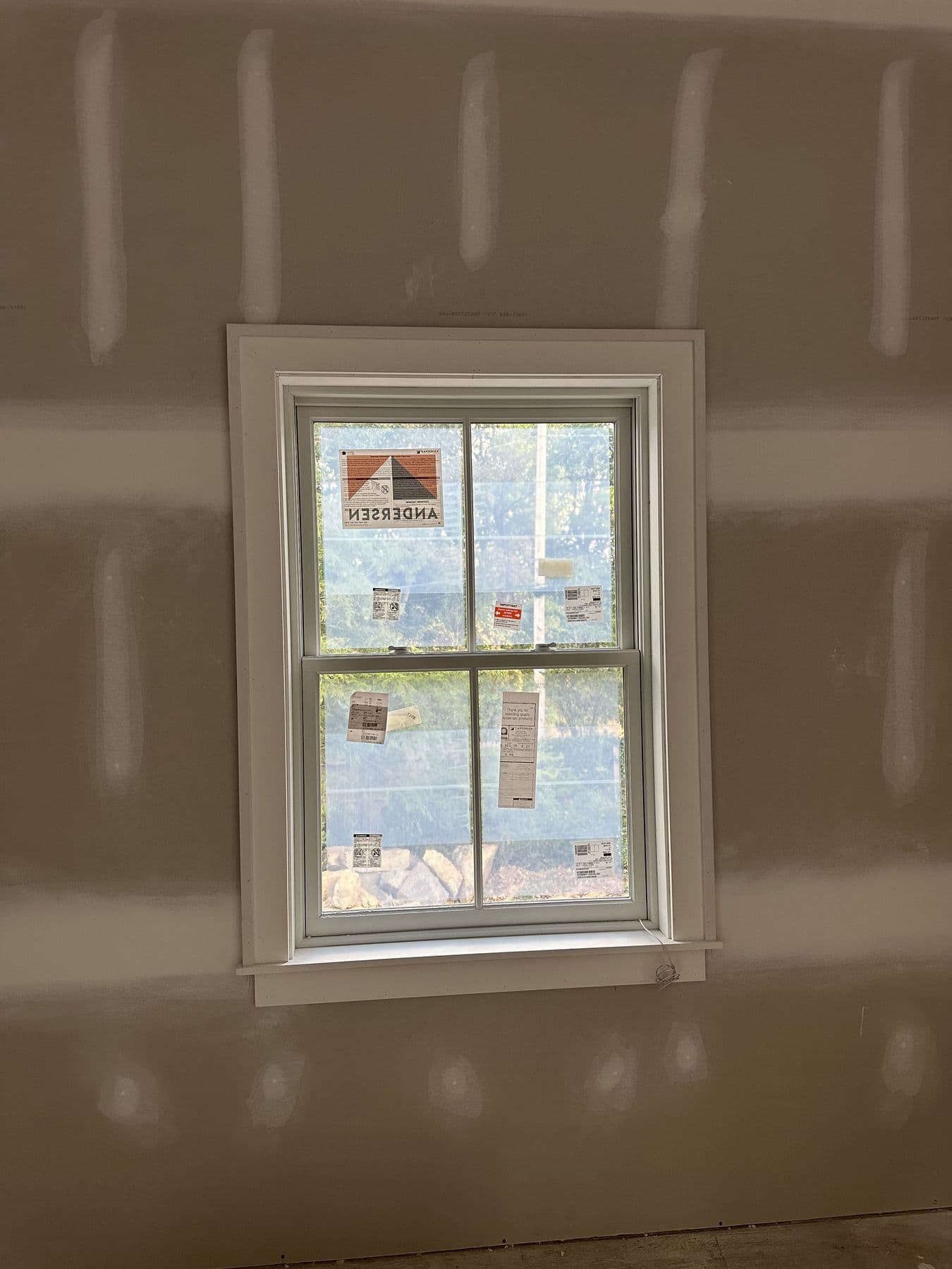 Tall double-hung window trimmed with a flat casing and stool