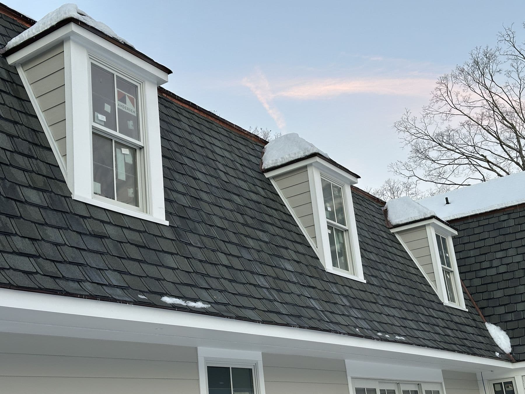 New shingled gambrel roof with dormers trimmed in white