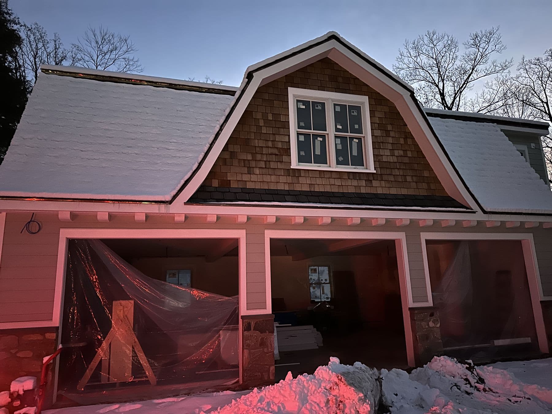 Gambrel gable in cedar shakes above the porch, evening light
