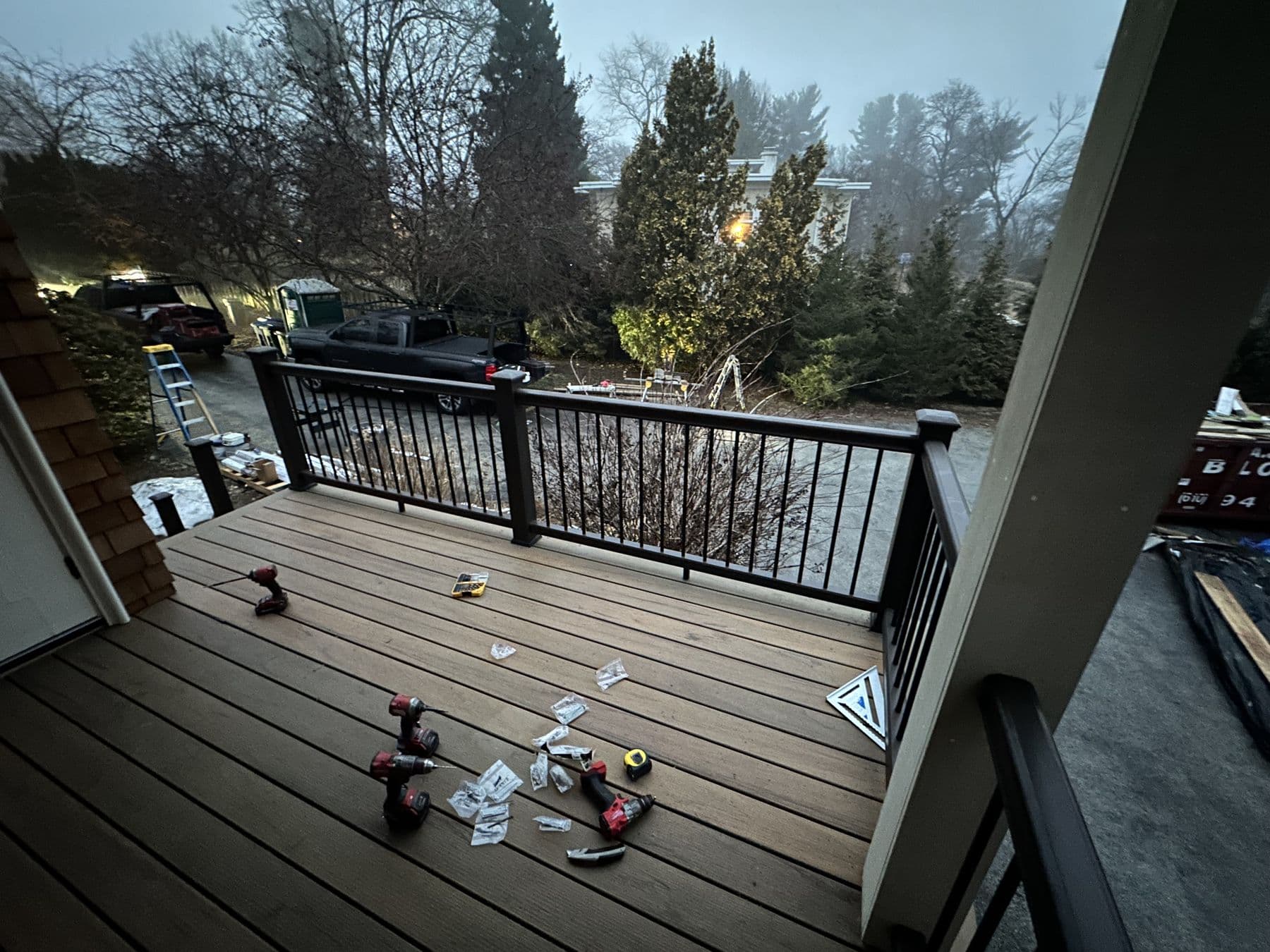 Composite deck with black aluminum railing off a cedar shake house