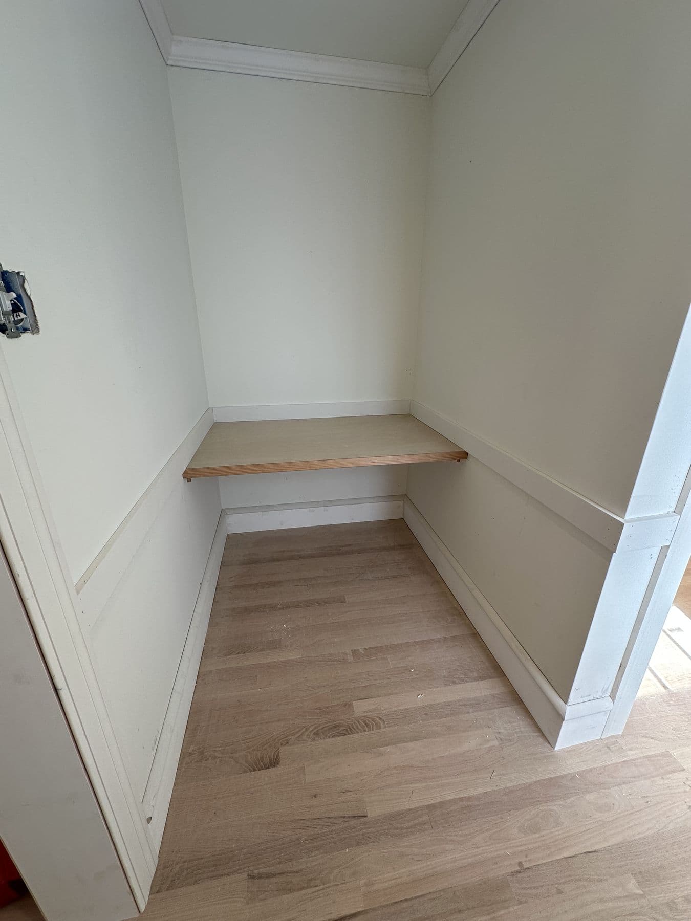Built-in desk under a sloped ceiling with wainscot below