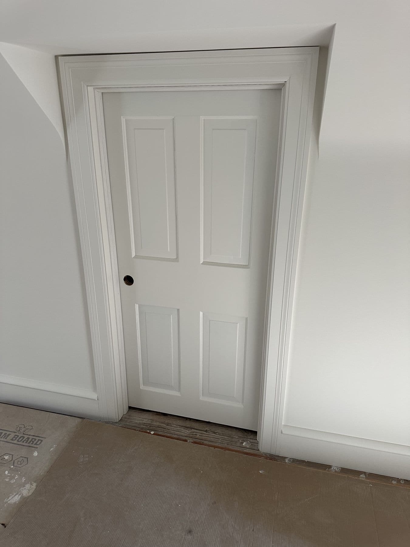 Four-panel door with new casing in an unfinished room