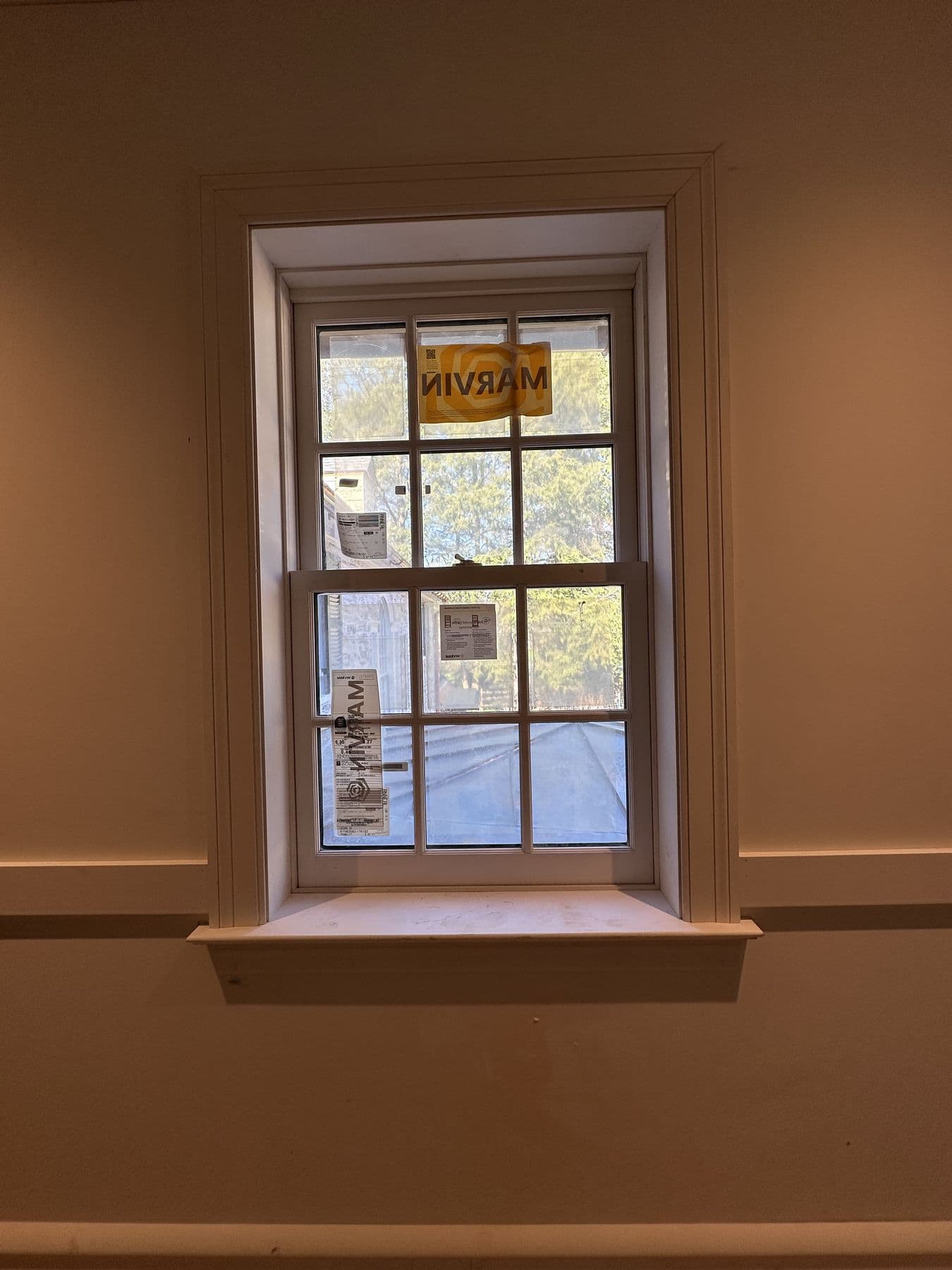 Double-hung window with full casing, stool and apron on a painted wall