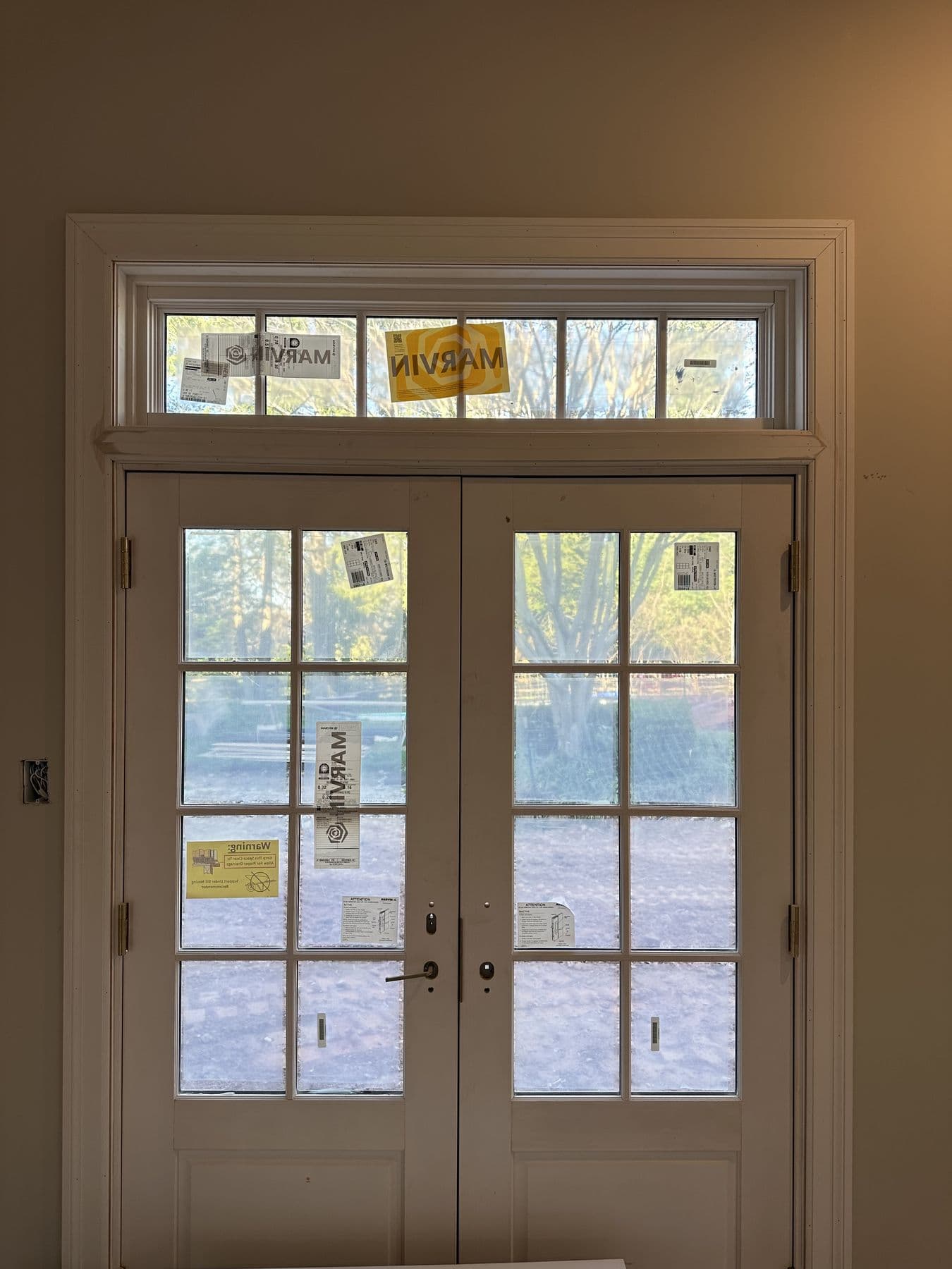 Tall French doors with divided lites and a transom