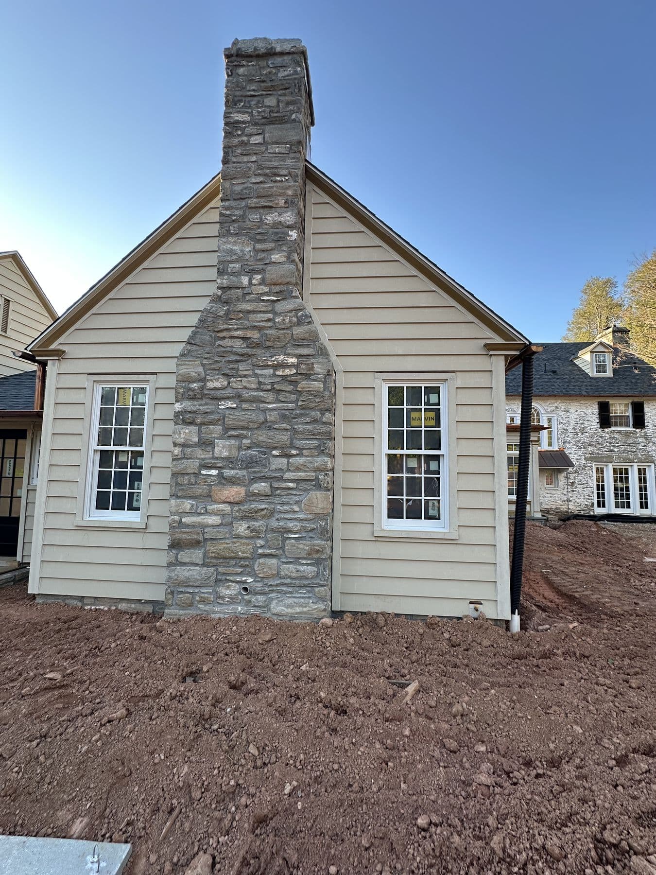 Stone chimney between cream lap siding walls